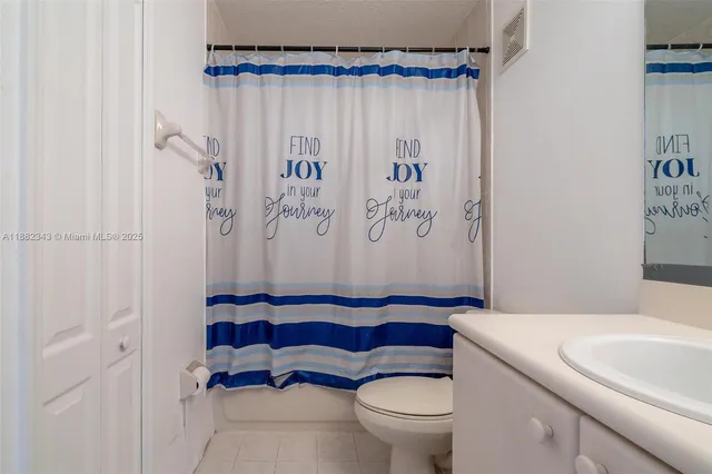 a bathroom with a toilet and a shower curtain