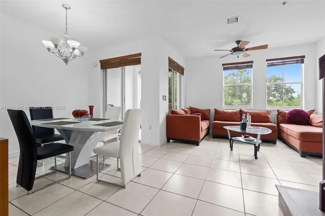 a living room with furniture two window and a chandelier
