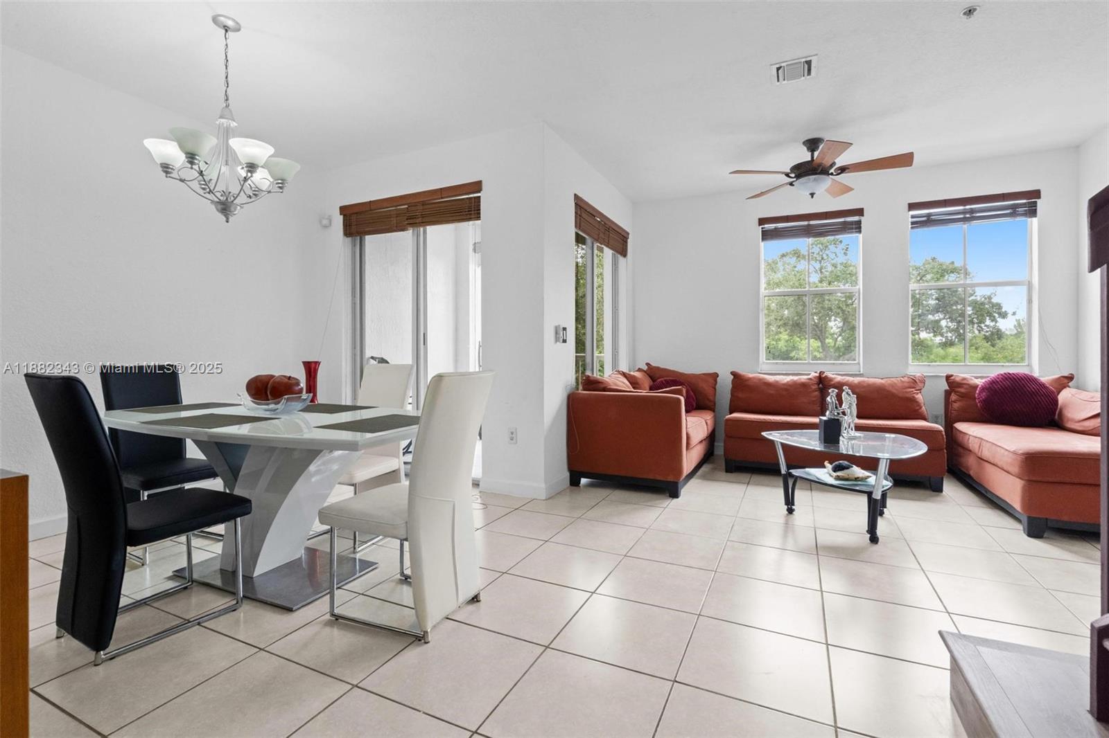 4455 Southwest 160th Avenue, Unit 205 Miramar, FL 33027 - Photo 6 of 44 a living room with furniture two window and a chandelier