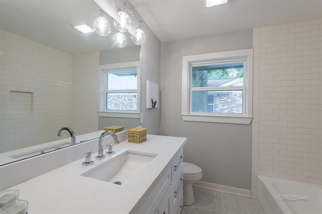 10058 Larston Street Houston, TX 77055 - Photo 16 of 18 a bathroom with a toilet a sink a mirror and a window