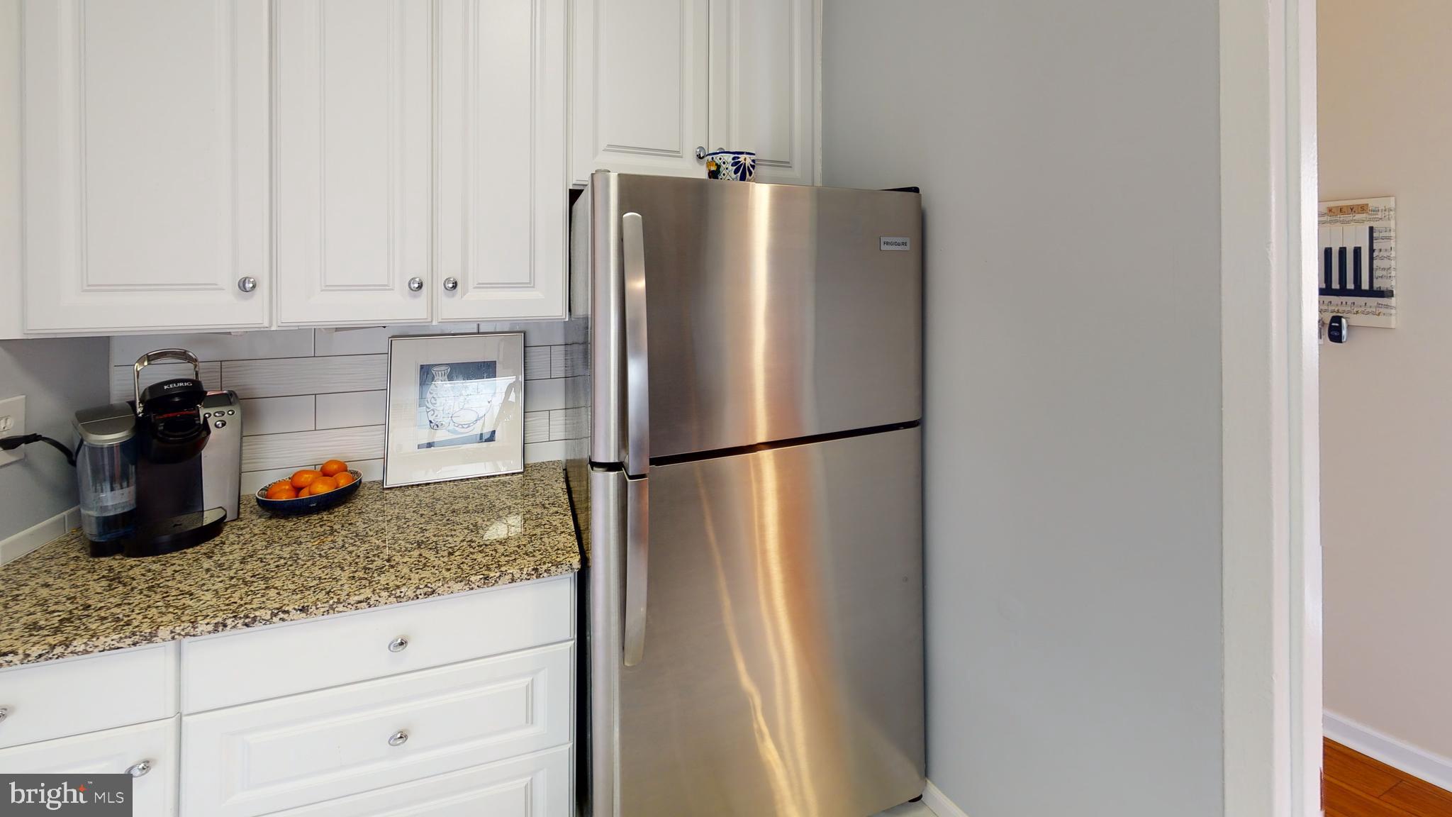 1111 Arlington Boulevard, Unit 731 Arlington, VA 22209 - Photo 8 of 46 a kitchen with granite countertop a refrigerator and cabinets