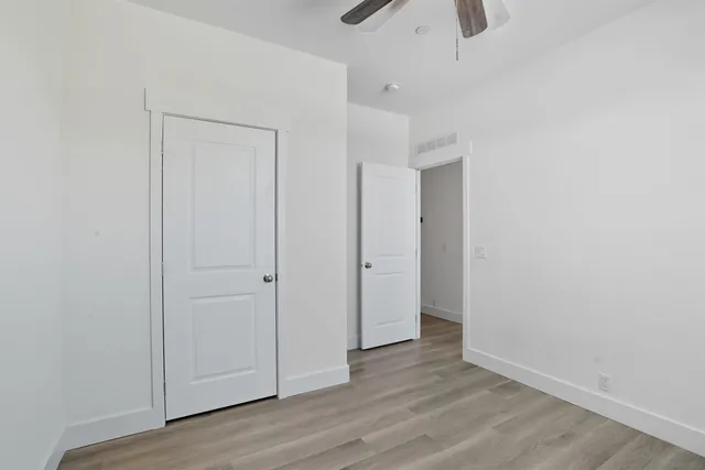 an empty room with wooden floor and closet