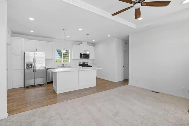 a large white kitchen with a refrigerator a stove top oven a sink and dishwasher