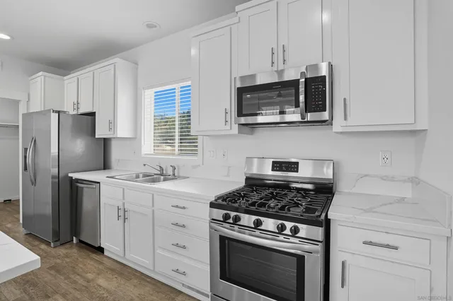 a kitchen with cabinets stainless steel appliances and a counter space