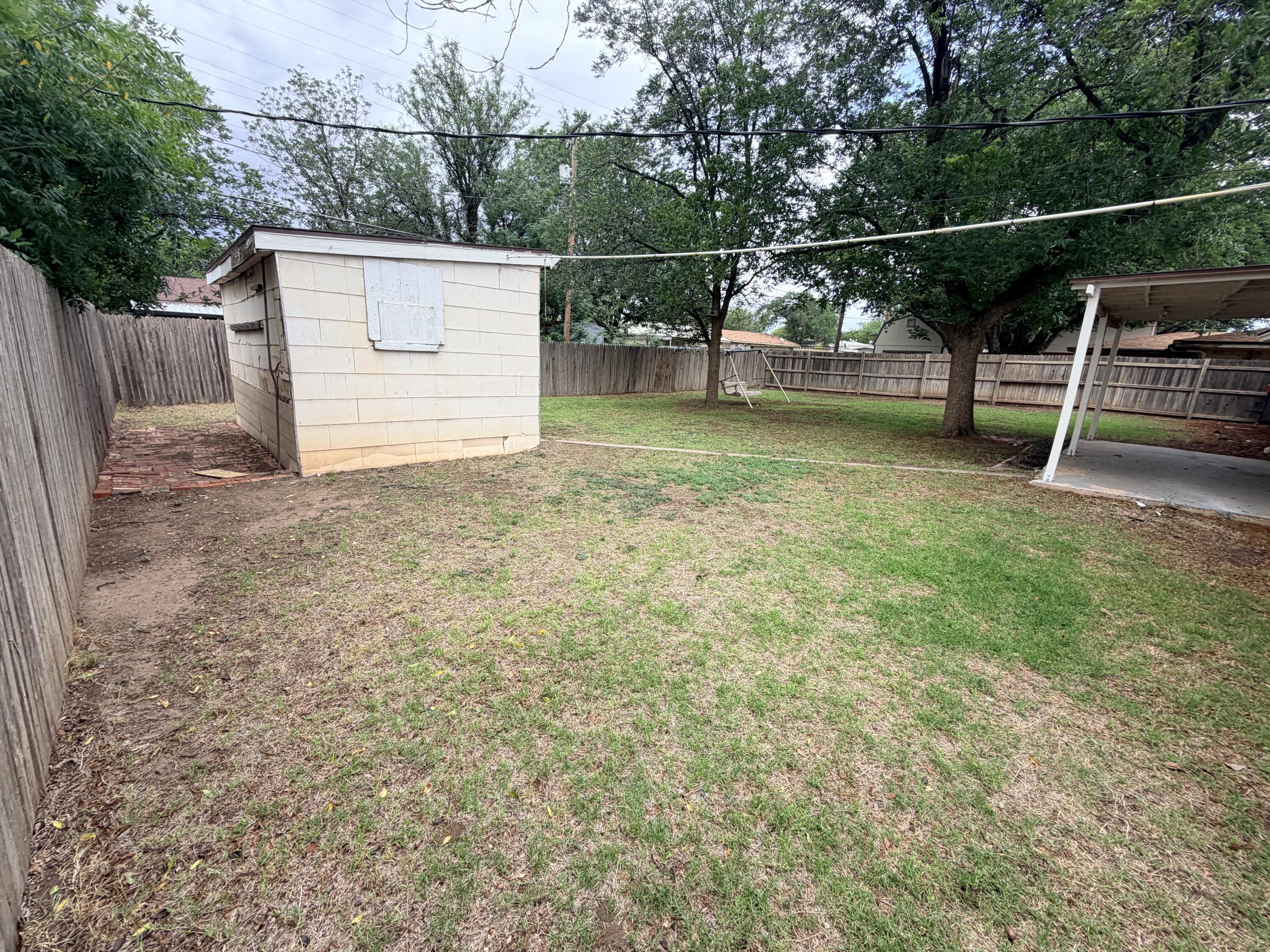 3814 27th Street Lubbock, TX 79410 - Photo 23 of 24 a view of a backyard with wooden fence and a bench