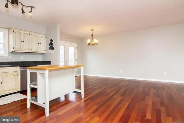 a kitchen with granite countertop wooden floors and white cabinets