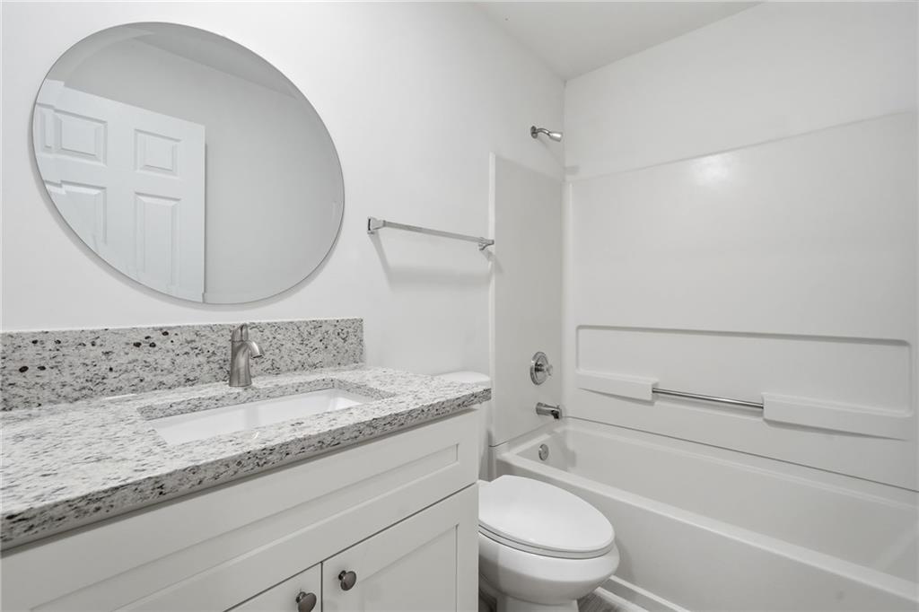 3349 Lathenview Court Alpharetta, GA 30004 - Photo 22 of 48 a bathroom with a granite countertop toilet sink and mirror