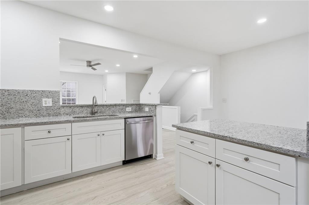 3349 Lathenview Court Alpharetta, GA 30004 - Photo 6 of 48 a kitchen with granite countertop white cabinets and white appliances
