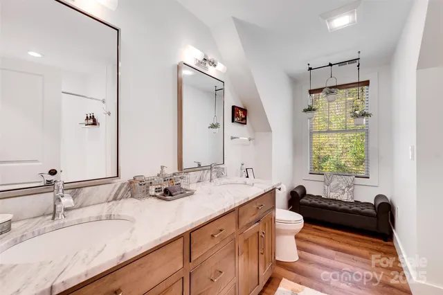 a en suite bathroom with a granite countertop sink and a mirror