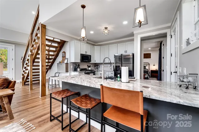 a kitchen with stainless steel appliances granite countertop a refrigerator a stove and a sink with granite countertops