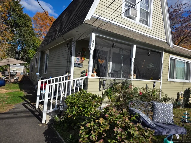 a view of a house with backyard and sitting area