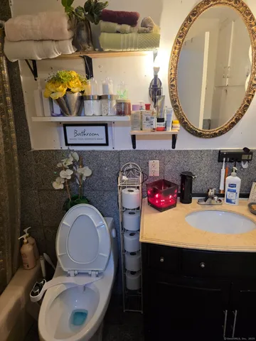a bathroom with a toilet a sink and a mirror