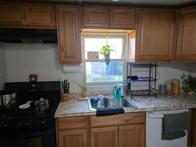 a kitchen with granite countertop kitchen island white cabinets and a window