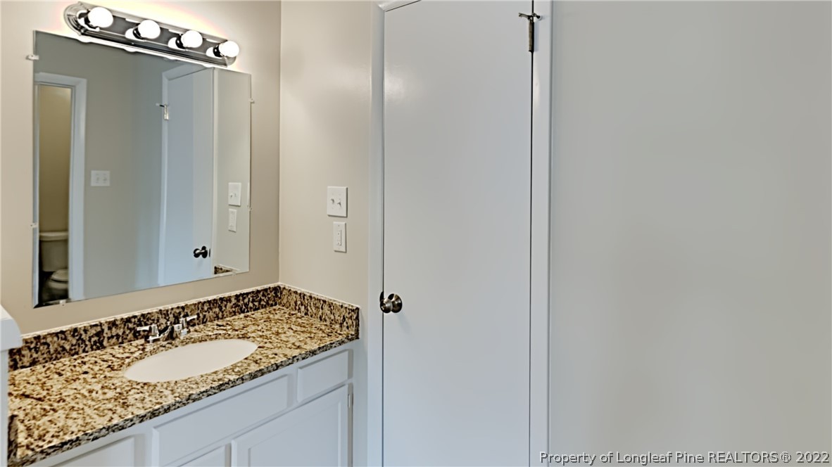 1759 Rim Road Fayetteville, NC 28314 - Photo 8 of 15 a bathroom with a granite countertop sink and a mirror