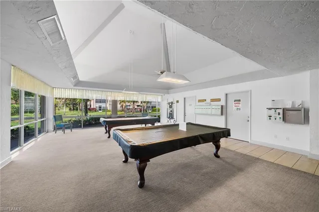 a living room with furniture pool table and a large window
