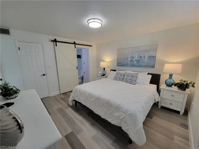 a bedroom with a bed and a painting on the wall