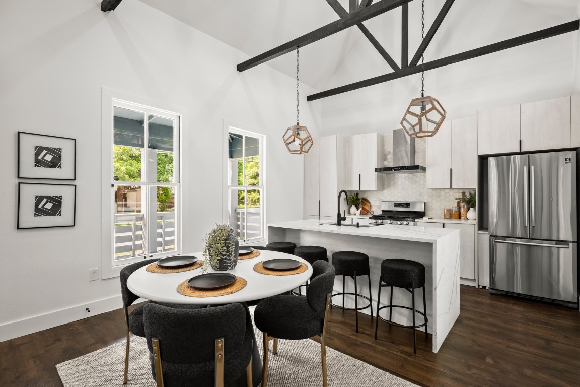 Dining room featuring high vaulted ceiling, dark wood-style flooring, and baseboards