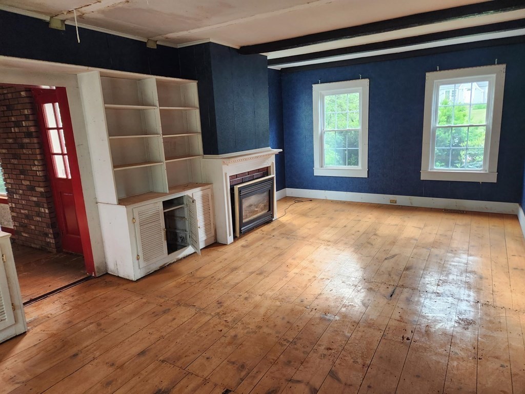 48 Main Street Wales, MA 01081 - Photo 16 of 42 a view of an empty room with a fireplace and a window