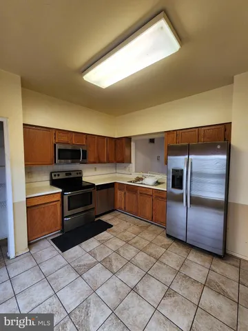 a kitchen with stainless steel appliances kitchen island granite countertop a sink counter space and cabinets