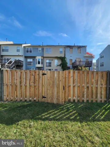 a view of a backyard with potted plants and wooden fence