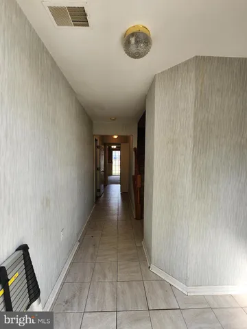 a view of a hallway to room with a window