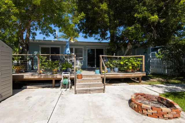 a view of house with backyard outdoor seating and trees