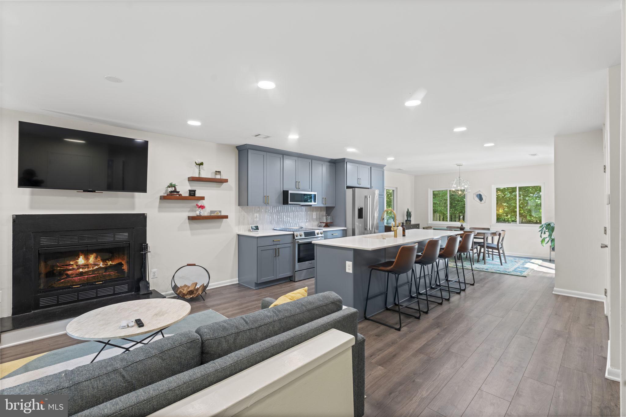11308 Gatesborough Lane Reston, VA 20191 - Photo 1 of 58 a living room with stainless steel appliances furniture a fireplace a flat screen tv and a kitchen view