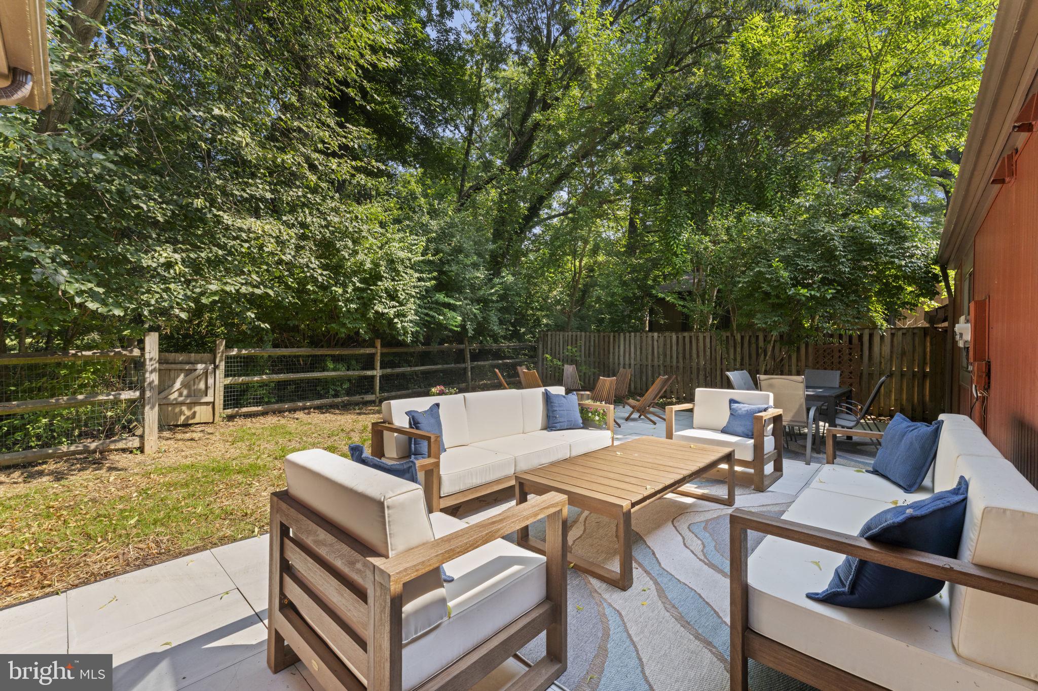 11308 Gatesborough Lane Reston, VA 20191 - Photo 14 of 58 a view of a patio with couches table and chairs and potted plants with wooden floor and fence