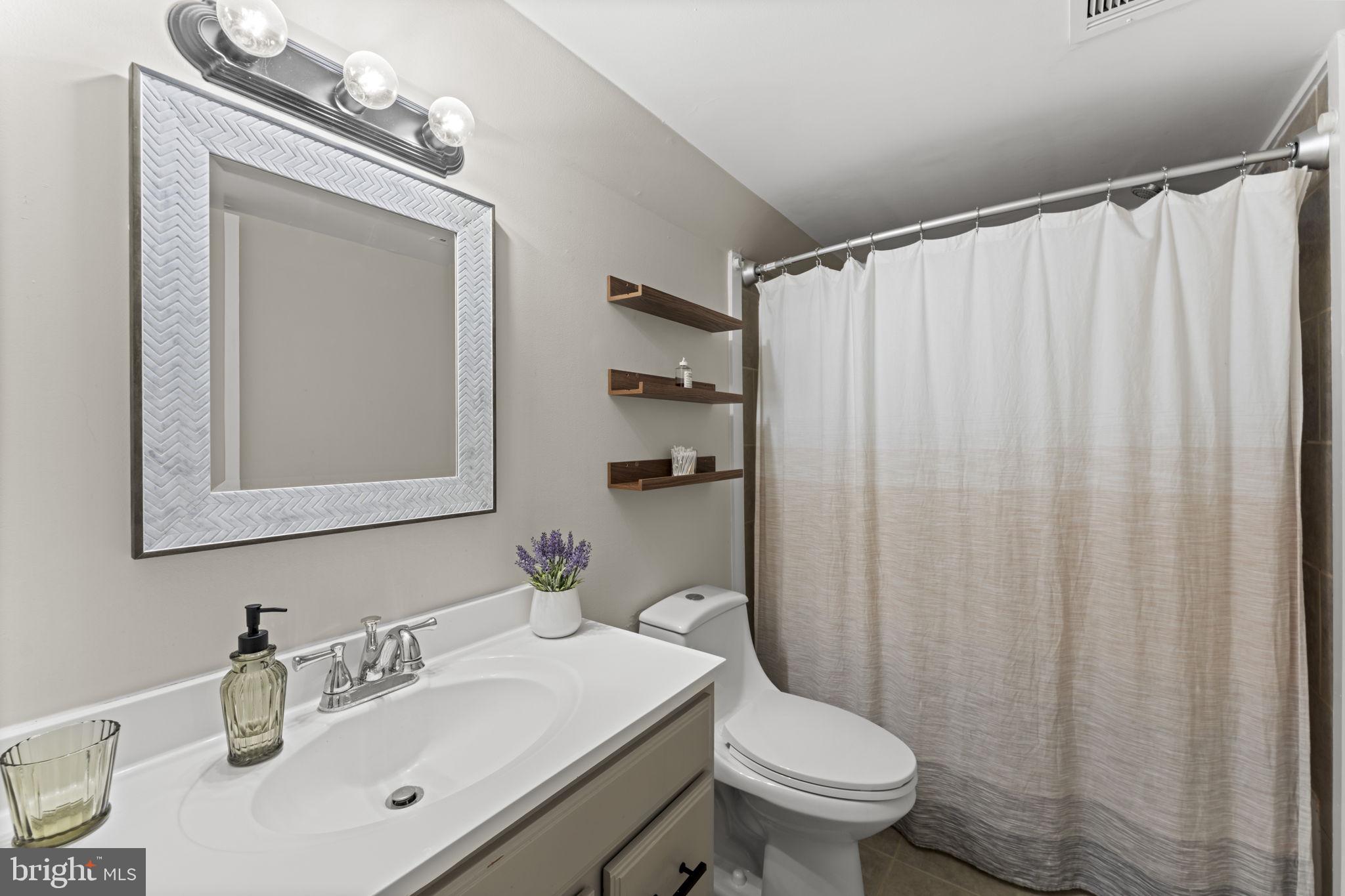 11308 Gatesborough Lane Reston, VA 20191 - Photo 33 of 58 a bathroom with a sink a toilet and shower curtain