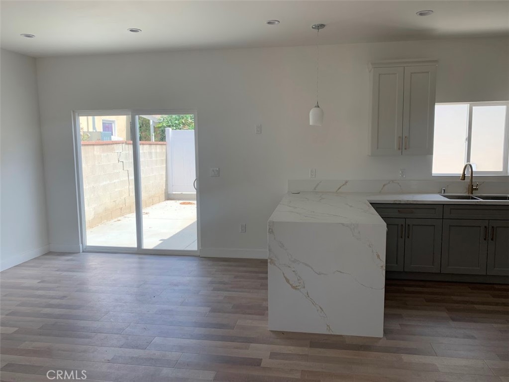 19509 Enadia Way Reseda, CA 91335 - Photo 3 of 15 a room with a sink cabinets and wooden floor