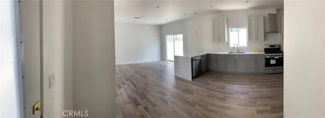 a view of a kitchen with wooden floor and electronic appliances