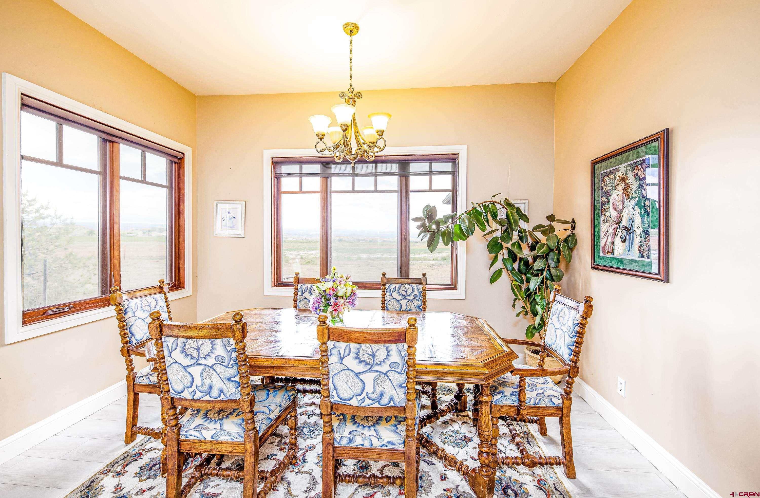 69392 Racine Road Montrose, CO 81401 - Photo 20 of 32 a view of a dining room with furniture large windows and wooden floor