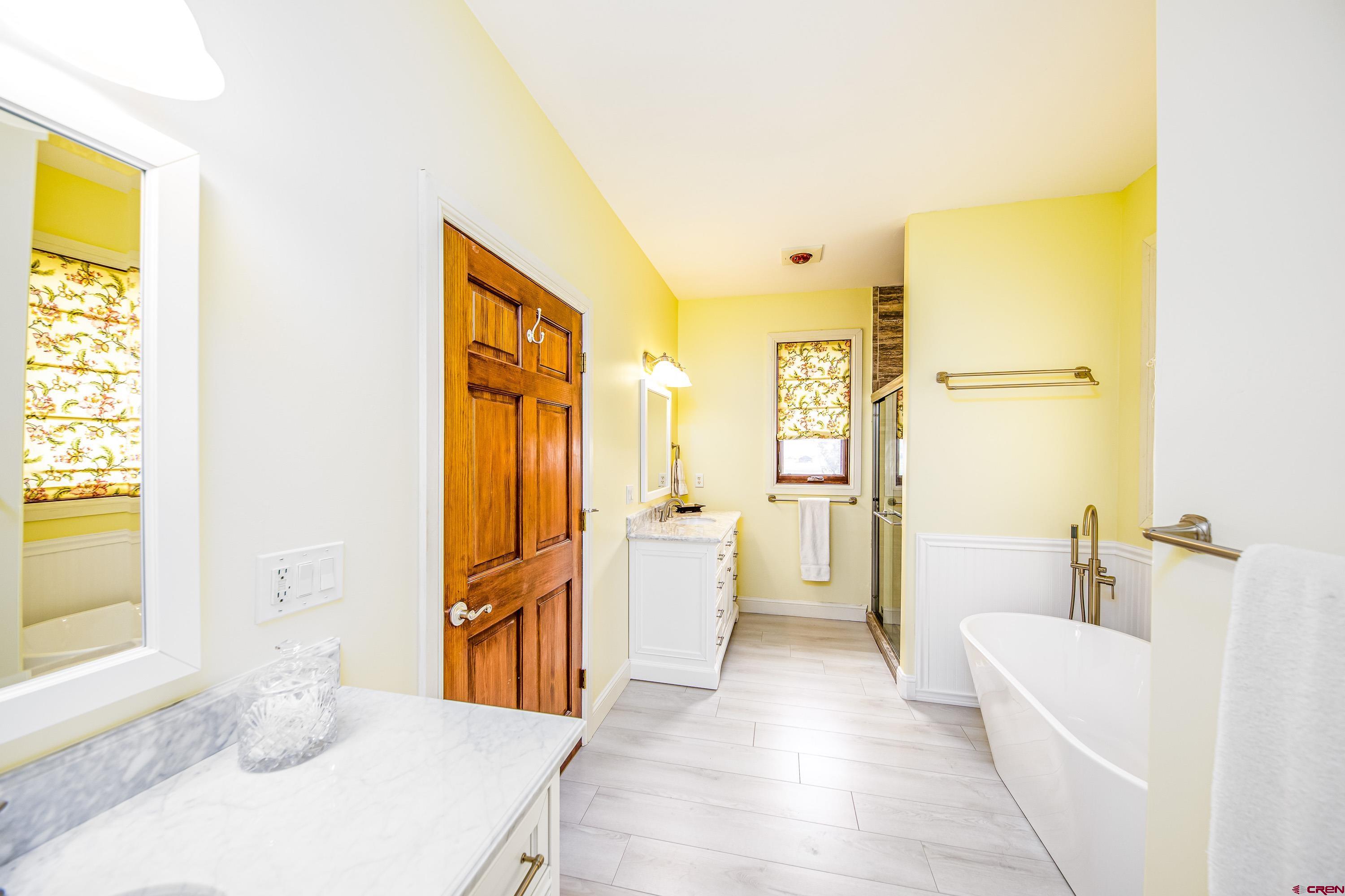 69392 Racine Road Montrose, CO 81401 - Photo 25 of 32 a bathroom with a tub sink and a mirror