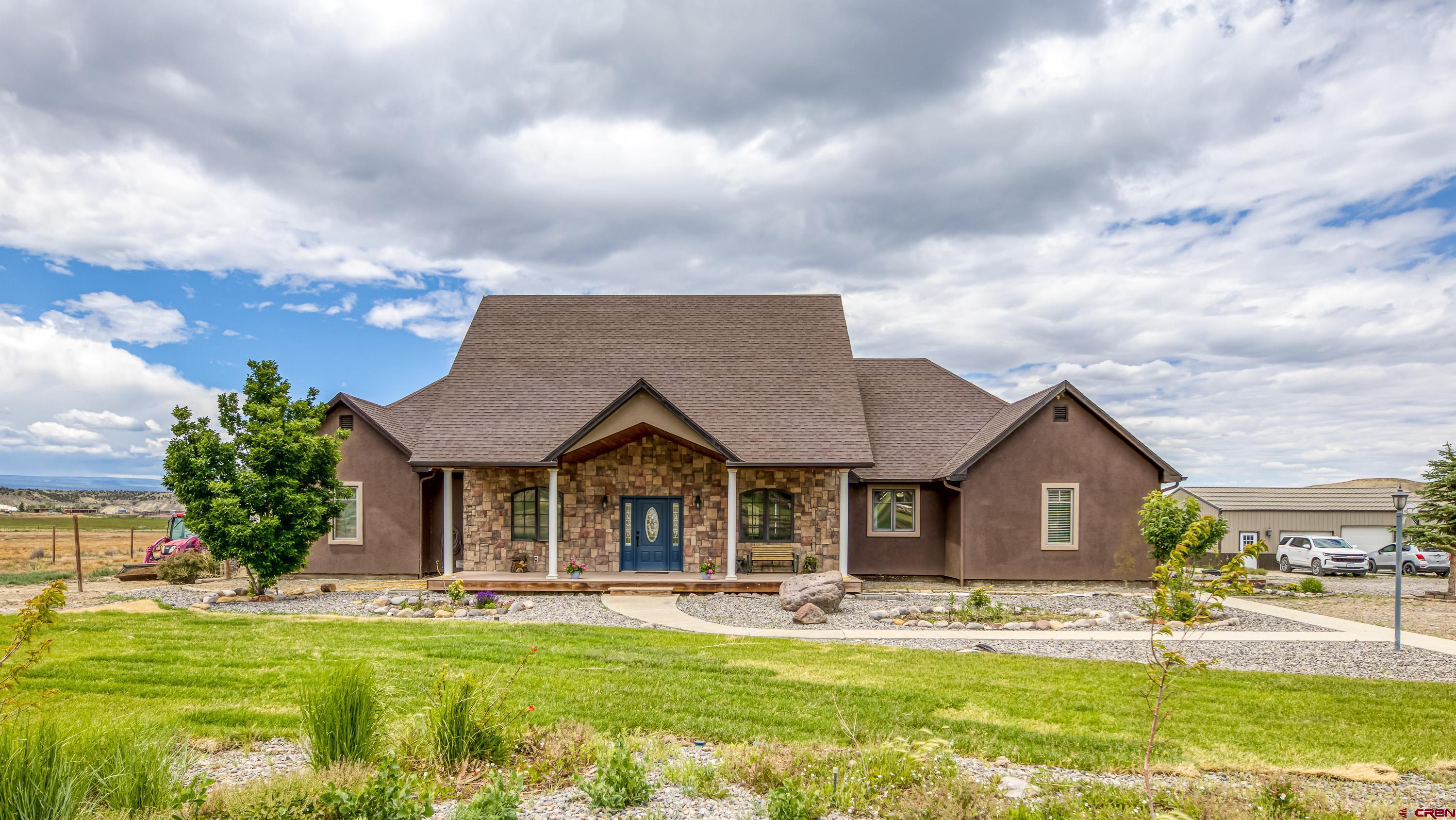 69392 Racine Road Montrose, CO 81401 - Photo 7 of 32 a front view of a house with a garden and pathway