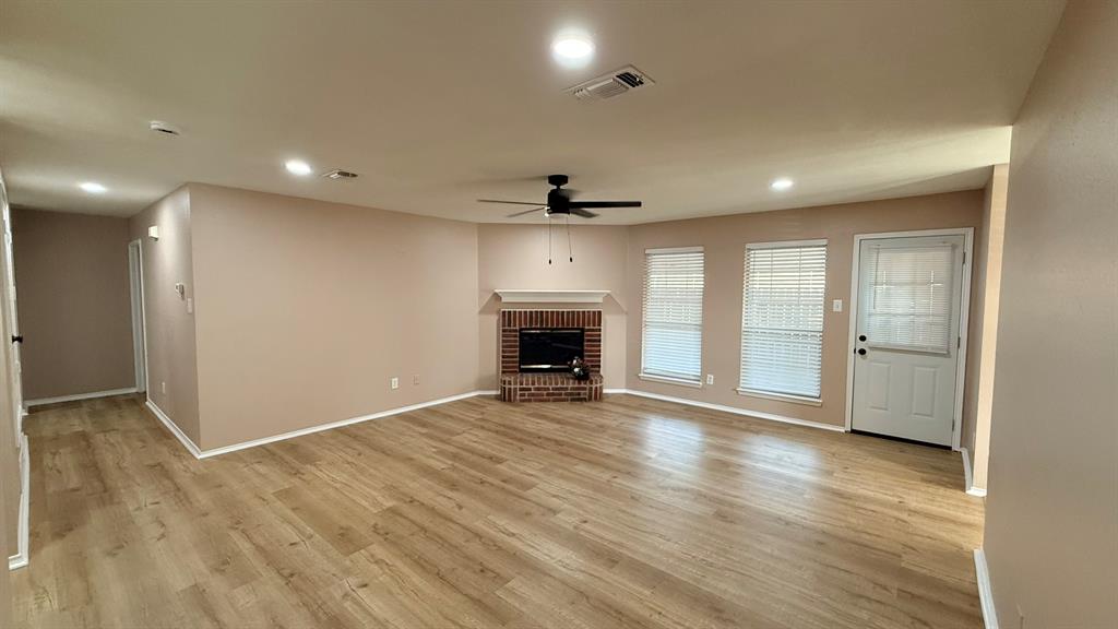 12259 Rim Rock Road Dallas, TX 75253 - Photo 2 of 17 Unfurnished living room featuring a fireplace, ceiling fan, recessed lighting, and light wood-type flooring