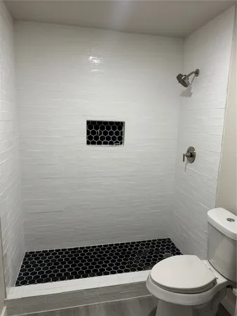 a bathroom with a toilet and a shower
