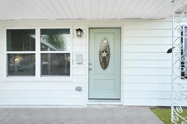 a side view of a house with a door and a window