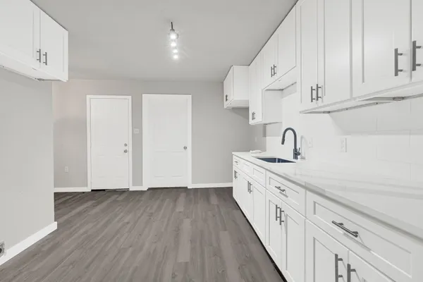 a kitchen with cabinets wooden floor and stainless steel appliances