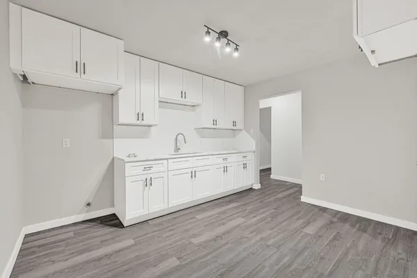 a kitchen with stainless steel appliances white cabinets and wooden floors