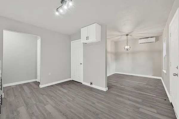 an empty room with wooden floor and a ceiling fan