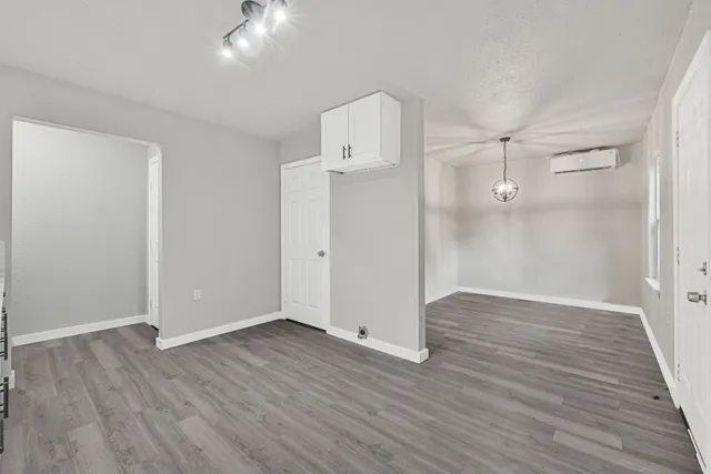 an empty room with wooden floor and a ceiling fan