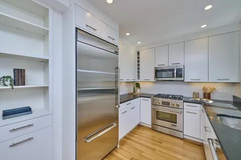 a kitchen with stainless steel appliances granite countertop a stove and a refrigerator