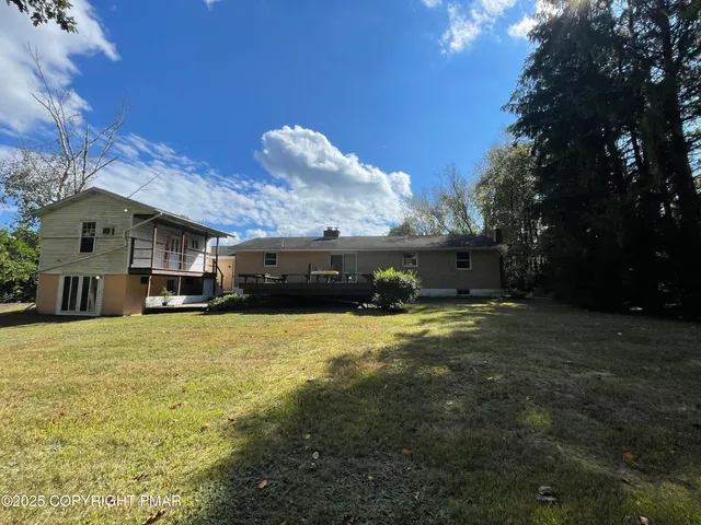 a front view of house with yard and trees in the background