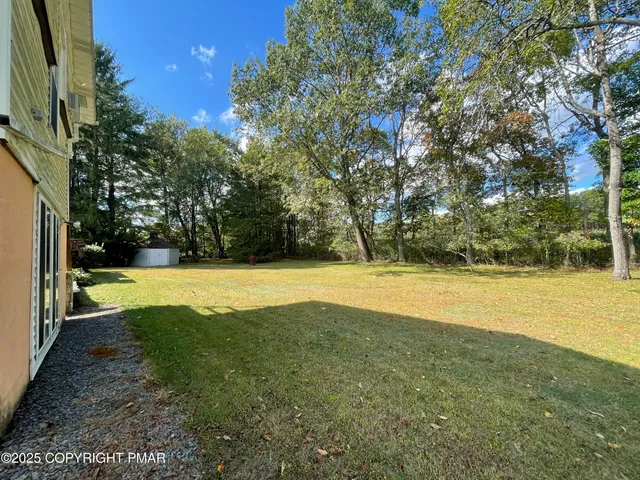 a view of yard with swimming pool and green space