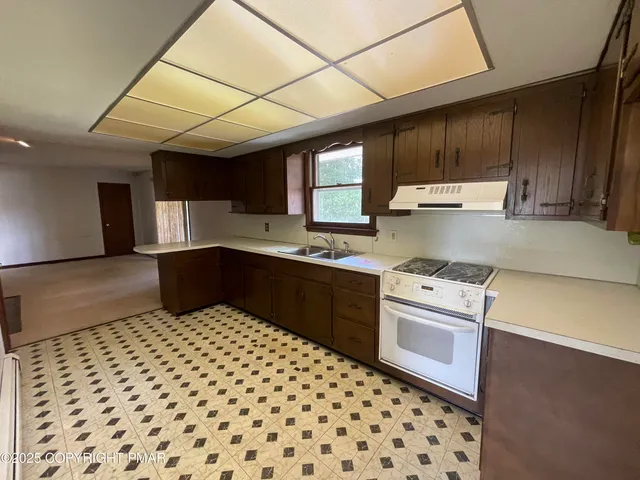 a kitchen with a sink a stove cabinets and a counter top space