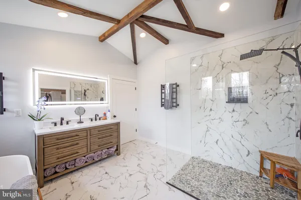 a kitchen with stainless steel appliances granite countertop a refrigerator a stove and a sink with wooden floor