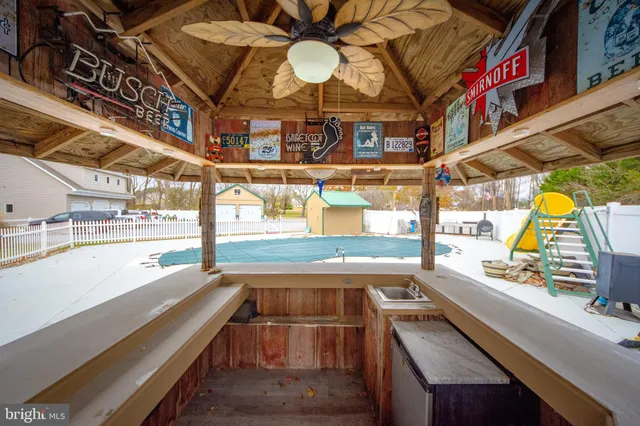 an aerial view of a house with swimming pool and large trees