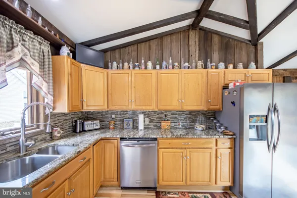 a kitchen with stainless steel appliances granite countertop a stove and cabinets