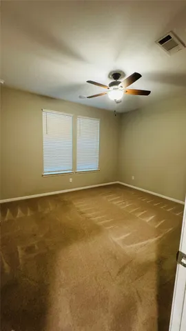 an empty room with a ceiling fan and window