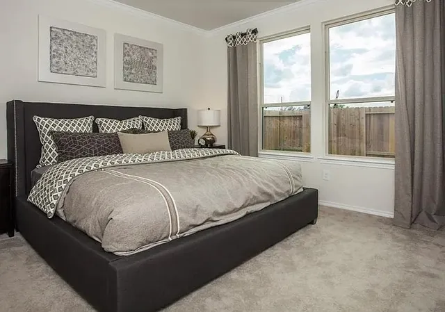 a bed sitting in a bedroom next to a window